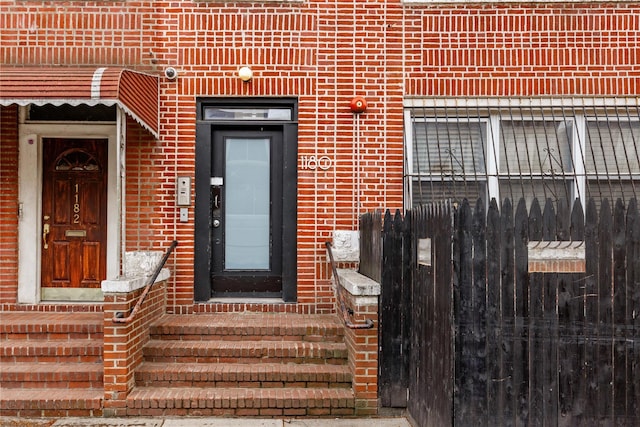 doorway to property with brick siding