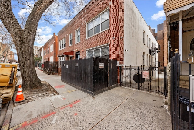 view of property exterior with a gate, fence, and a residential view