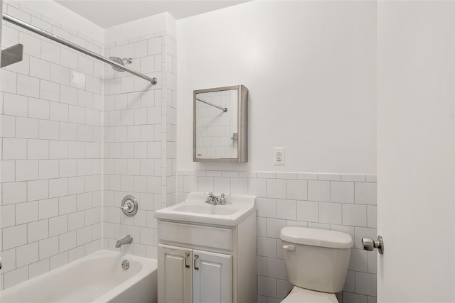 bathroom featuring a wainscoted wall, toilet, tile walls, shower / bath combination, and vanity