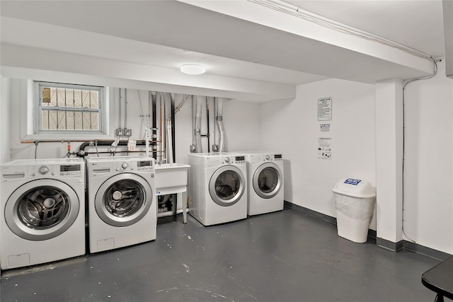 laundry area featuring washer and dryer, baseboards, and a sink