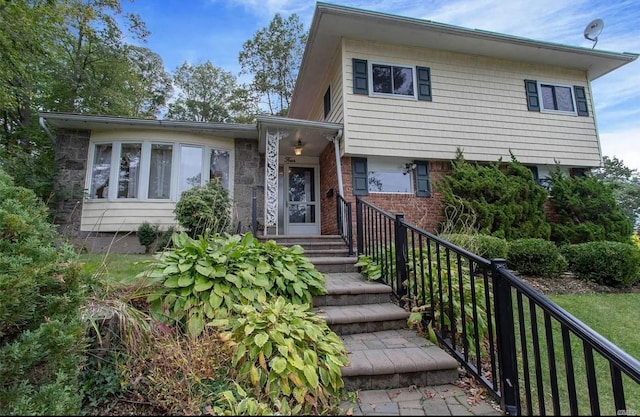 tri-level home with brick siding and fence