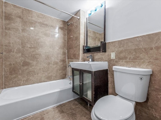 full bathroom with vanity, toilet, tile walls, and bathing tub / shower combination