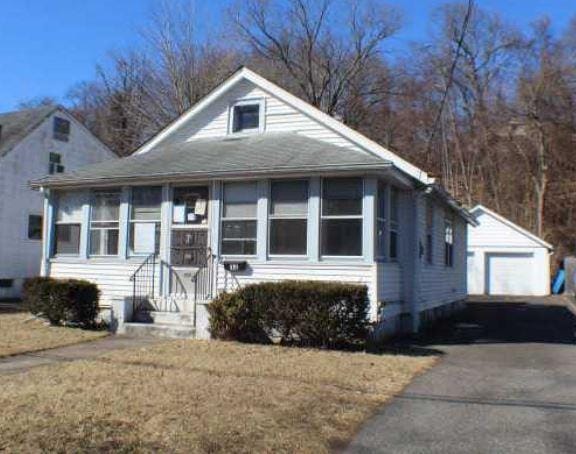 bungalow-style house with an outbuilding, driveway, and a detached garage