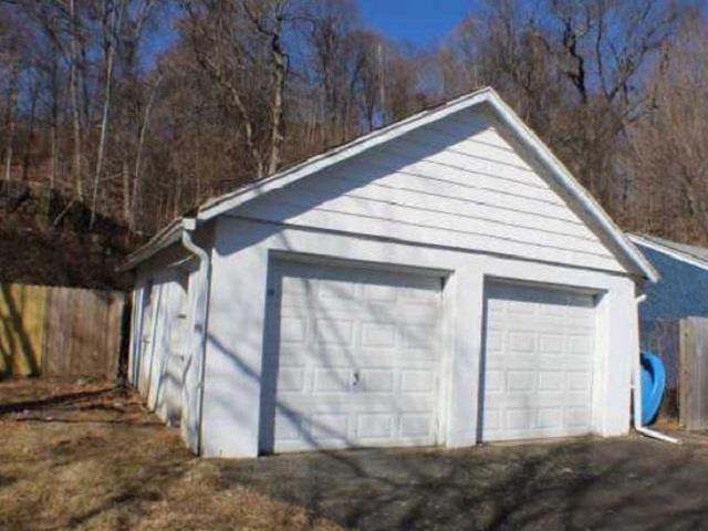 detached garage featuring fence