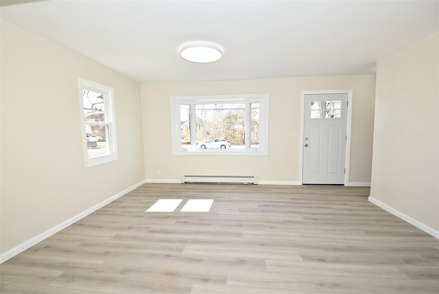 entrance foyer with a wealth of natural light, light wood-type flooring, a baseboard heating unit, and baseboards