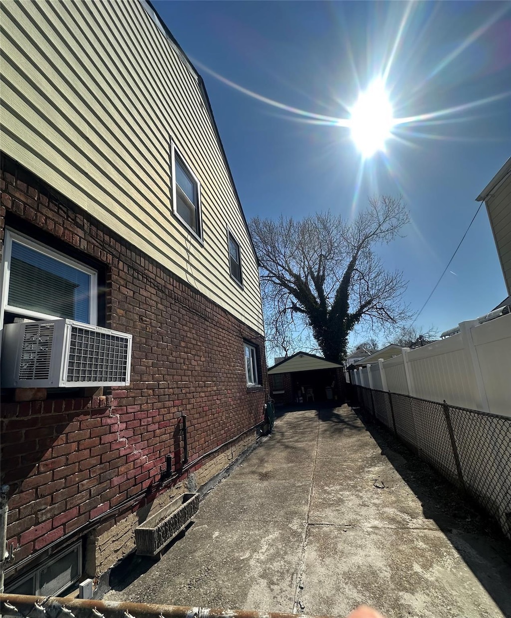 view of home's exterior featuring brick siding and fence