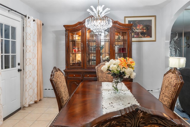 dining space with baseboard heating, a notable chandelier, arched walkways, and light tile patterned floors