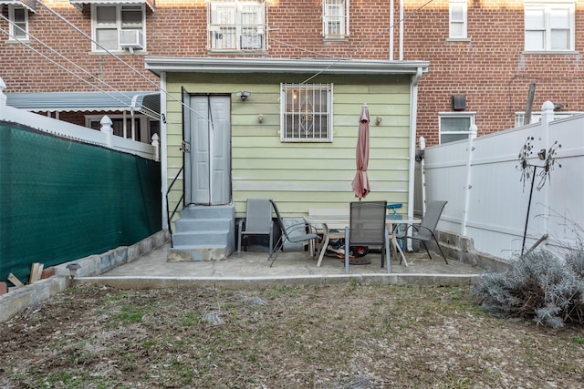 rear view of property featuring a patio area, a fenced backyard, and entry steps