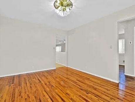 unfurnished room with wood finished floors and baseboards