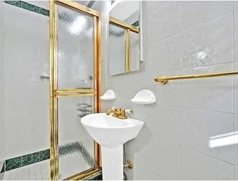 bathroom featuring tile walls and a shower stall