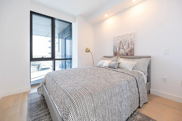 bedroom with light wood-style flooring and baseboards