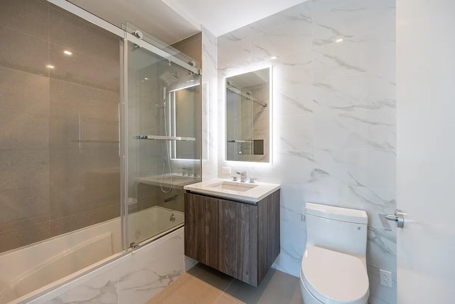 33-66 Farrington St Unit 15G, Flushing, NY 11354 - bathroom featuring vanity, tile walls, toilet, and enclosed tub / shower combo