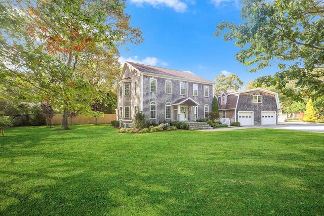 view of front of house with a front yard, fence, a garage, and driveway