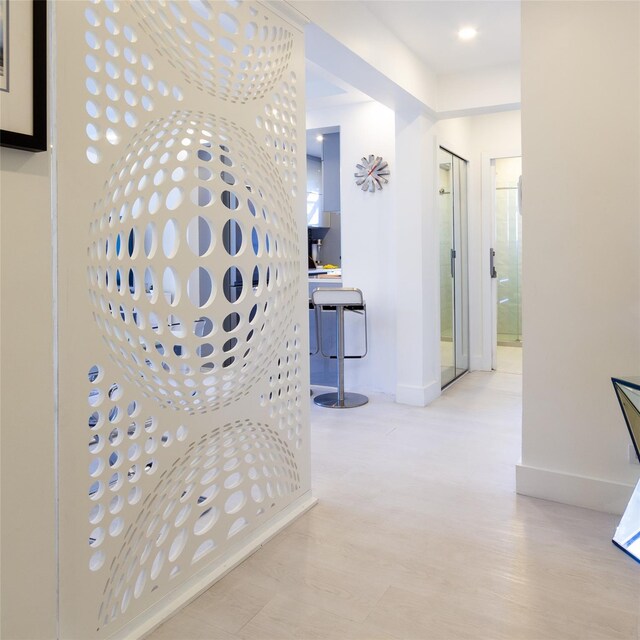 corridor with baseboards and wood finished floors