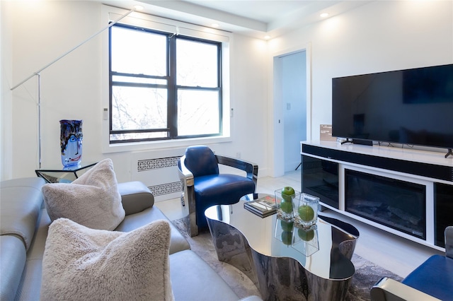 living area featuring a glass covered fireplace and recessed lighting