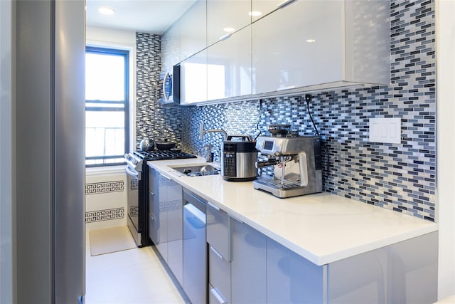 kitchen featuring plenty of natural light, appliances with stainless steel finishes, modern cabinets, and a sink