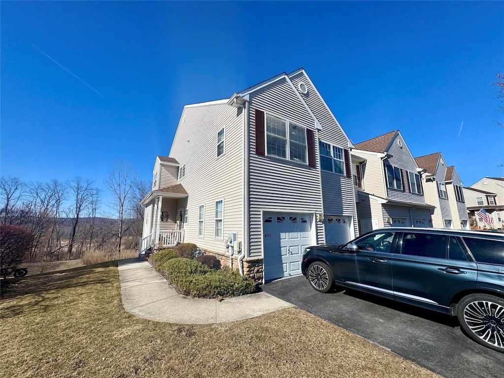 view of side of property with aphalt driveway, a residential view, and an attached garage