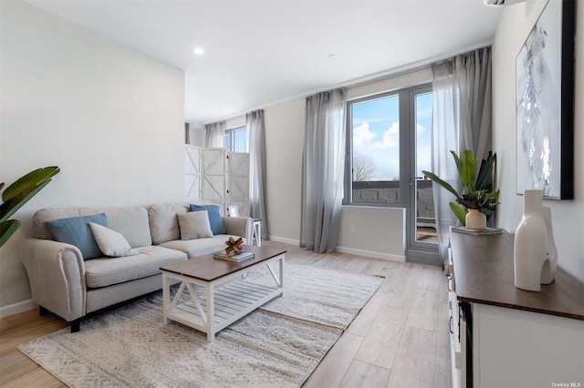 living room featuring recessed lighting, light wood-type flooring, and baseboards