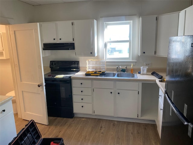 kitchen featuring under cabinet range hood, a sink, black appliances, and light wood-style floors