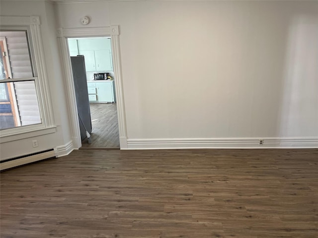 unfurnished room with baseboards and dark wood-style flooring
