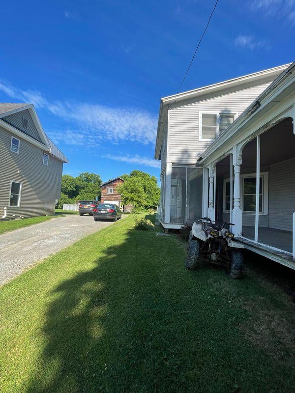 view of side of home with a lawn and a sunroom
