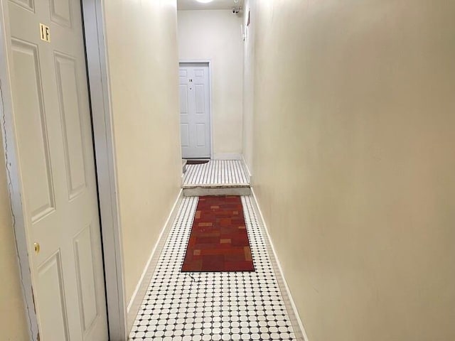 hallway with tile patterned floors and baseboards