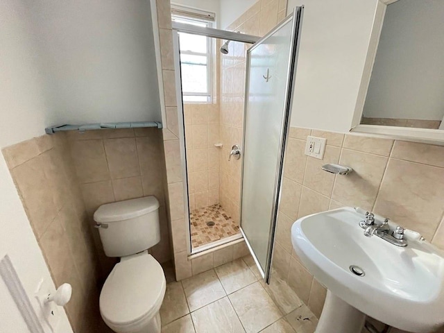 full bathroom with a sink, toilet, tile walls, and a shower stall