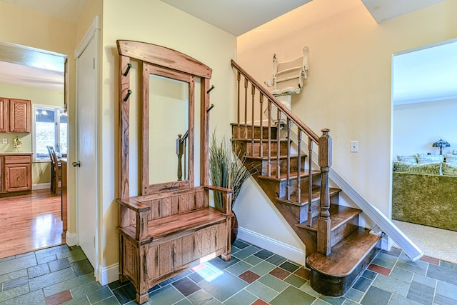 stairway with baseboards and stone tile flooring