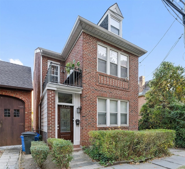 view of front of property featuring a balcony and brick siding