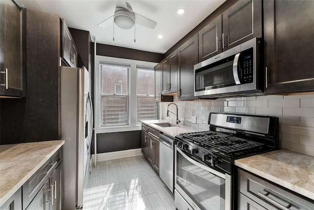 kitchen with tasteful backsplash, dark brown cabinets, light countertops, stainless steel appliances, and a sink