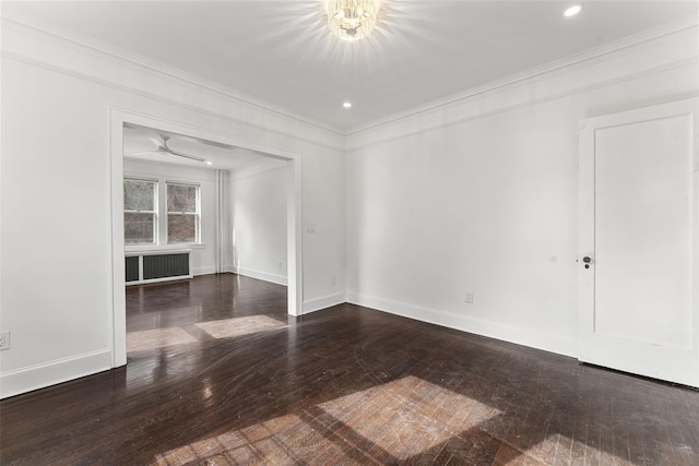 empty room featuring crown molding, baseboards, and hardwood / wood-style floors