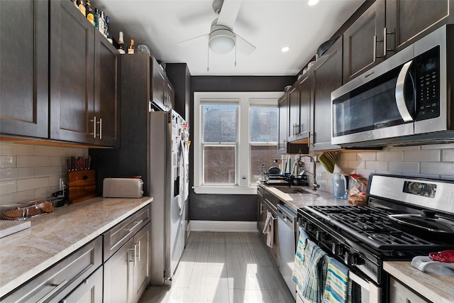 kitchen with baseboards, ceiling fan, dark brown cabinetry, appliances with stainless steel finishes, and backsplash