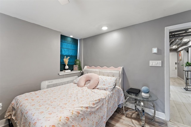 bedroom with wood finished floors and baseboards