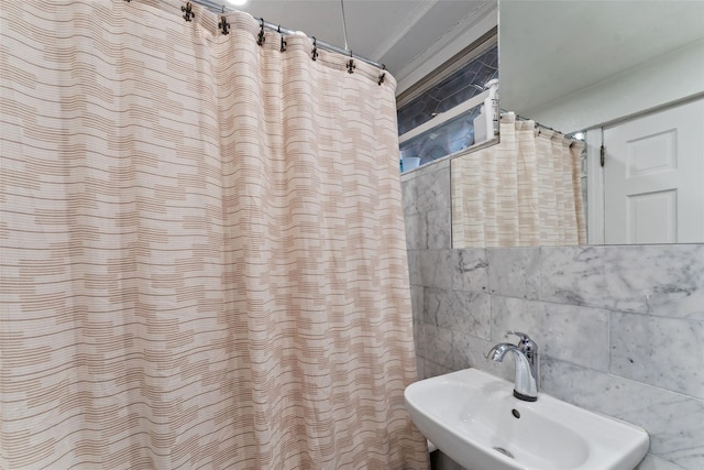 bathroom featuring a sink, curtained shower, tile walls, and crown molding