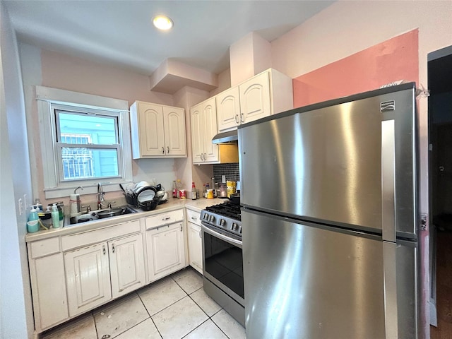 kitchen with a sink, stainless steel appliances, white cabinets, light countertops, and light tile patterned floors