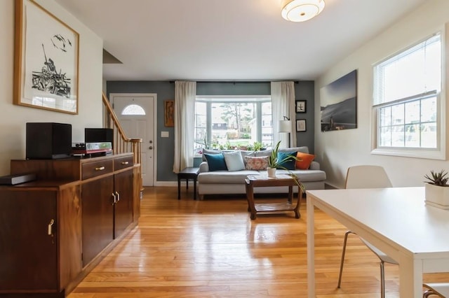 living area featuring stairs and light wood-type flooring