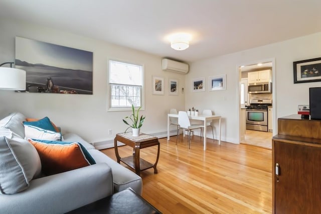 living room featuring baseboards, a wall mounted air conditioner, and light wood-style flooring