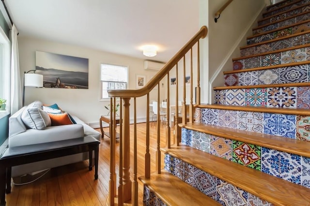 staircase featuring a wall mounted air conditioner and hardwood / wood-style floors