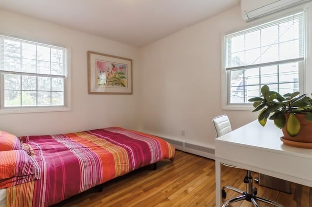 bedroom featuring light wood-style flooring and a wall unit AC