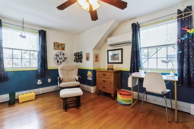 living area featuring a ceiling fan, a wall unit AC, a healthy amount of sunlight, and wood finished floors
