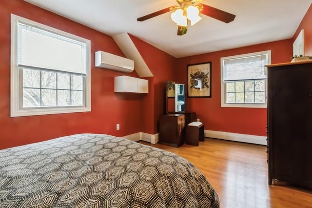 unfurnished bedroom with ceiling fan, baseboards, wood finished floors, a baseboard radiator, and a wall mounted AC