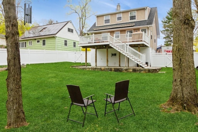 back of property featuring a fenced backyard, a gate, a wooden deck, and stairway