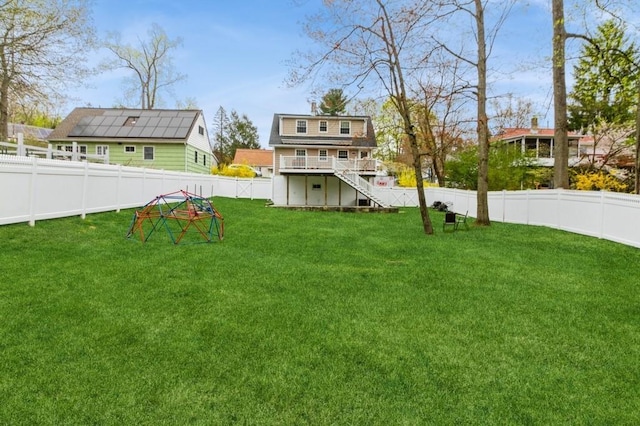 view of yard featuring a fenced backyard, a wooden deck, and stairway