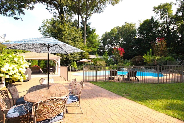 view of patio featuring a gazebo, outdoor dining area, fence, and a fenced in pool