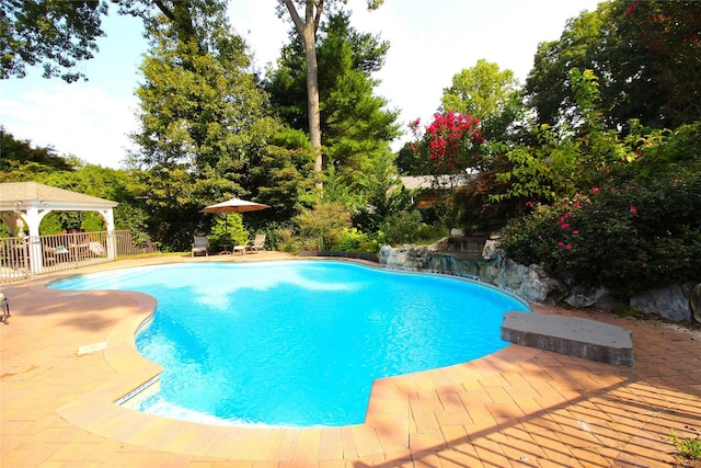 outdoor pool featuring fence and a patio area