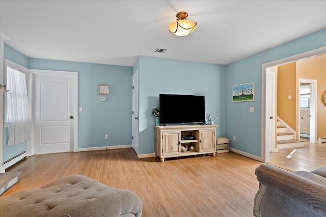 living area with stairs, light wood-style floors, visible vents, and baseboards