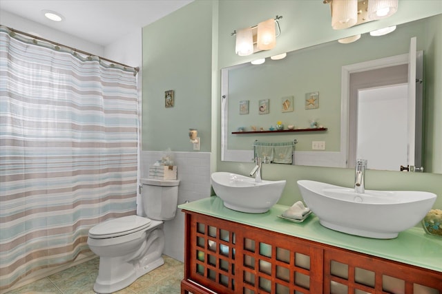 full bathroom featuring a sink, toilet, double vanity, and tile patterned floors