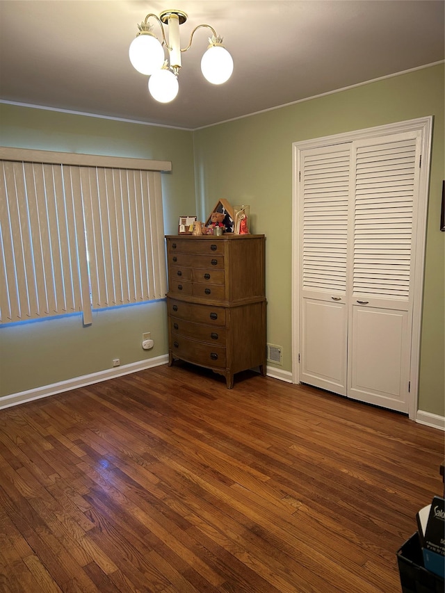 unfurnished bedroom with visible vents, dark wood-style flooring, and baseboards