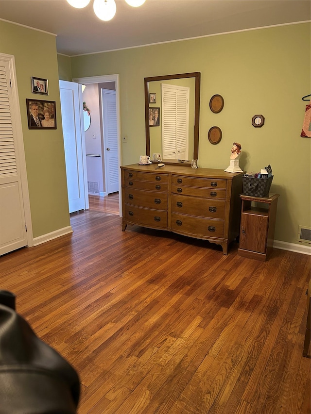 interior space featuring dark wood finished floors, visible vents, and baseboards