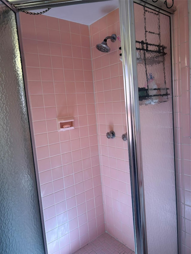 bathroom with a stall shower and a textured wall